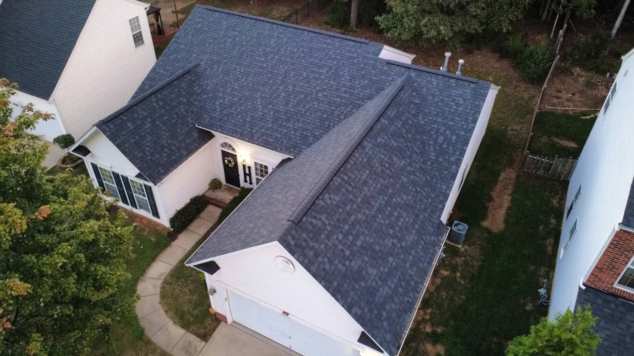 Drone photo of dark architectural shingle roof on a white home by Local Roofer NC