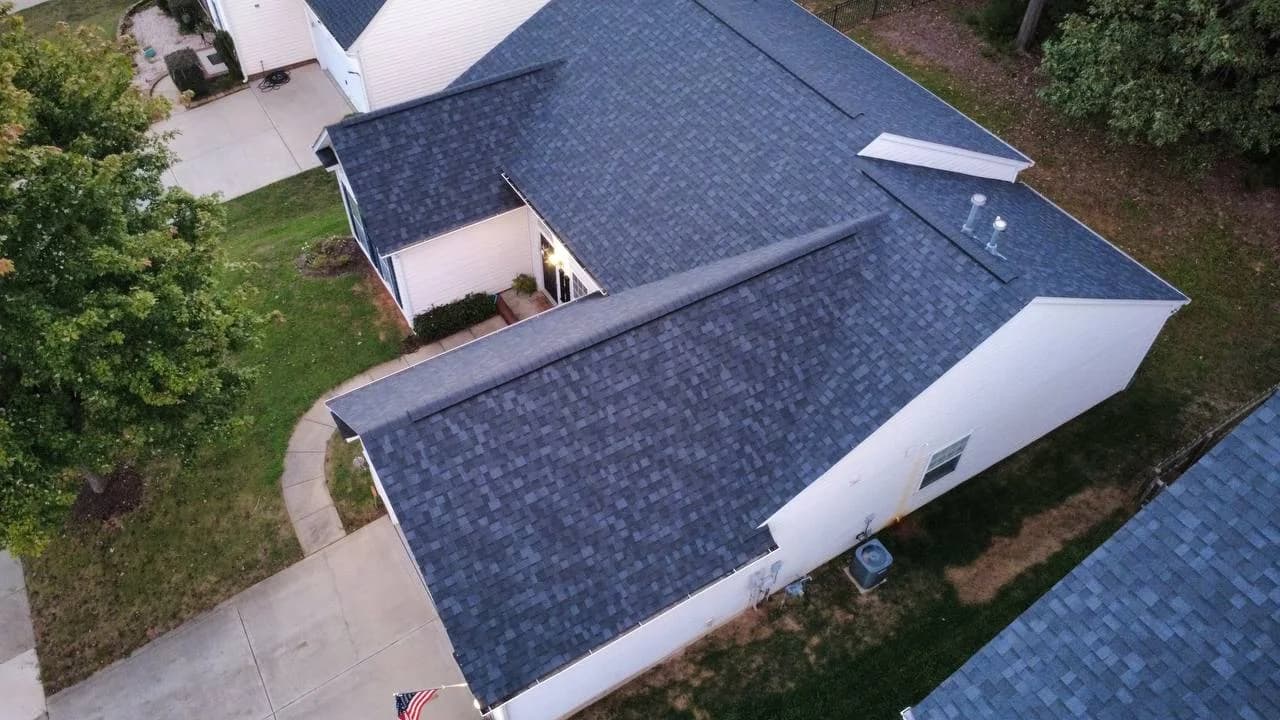 Side drone photo of completed architectural shingle roof on a residential home by Local Roofer NC